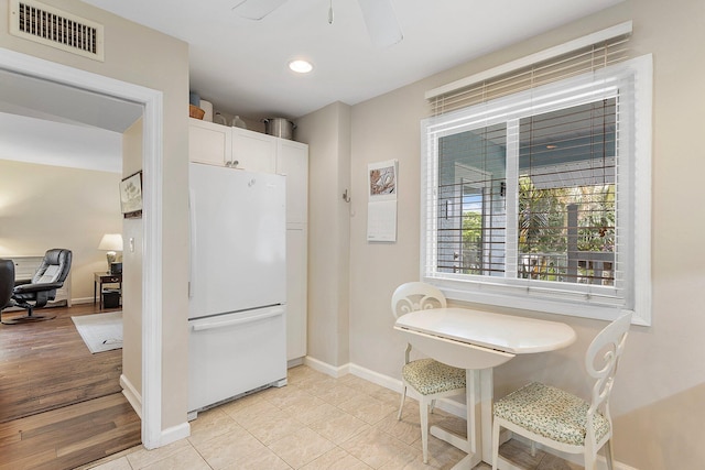 kitchen featuring white refrigerator, ceiling fan, light hardwood / wood-style flooring, and white cabinets