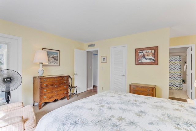 carpeted bedroom featuring ensuite bathroom and a closet