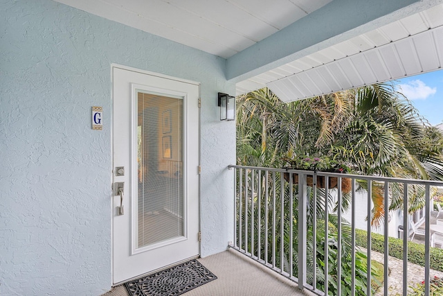 entrance to property featuring a water view and a balcony