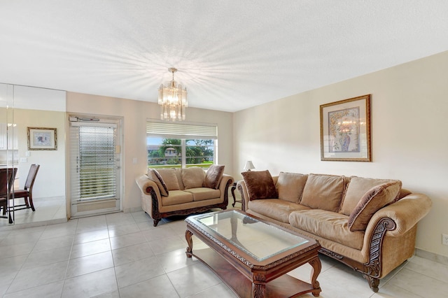 living room featuring a notable chandelier, light tile patterned floors, and a textured ceiling