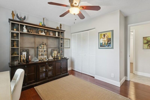 bar featuring ceiling fan, dark brown cabinetry, and dark hardwood / wood-style floors