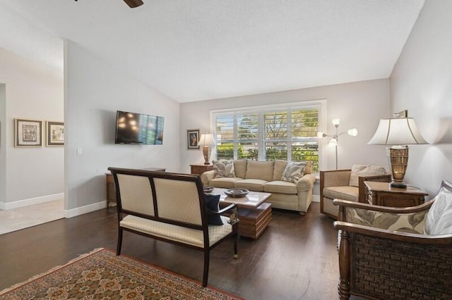 living room with dark hardwood / wood-style flooring, vaulted ceiling, and ceiling fan