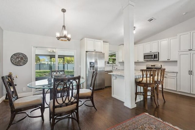 dining room featuring an inviting chandelier, lofted ceiling, dark hardwood / wood-style floors, and sink