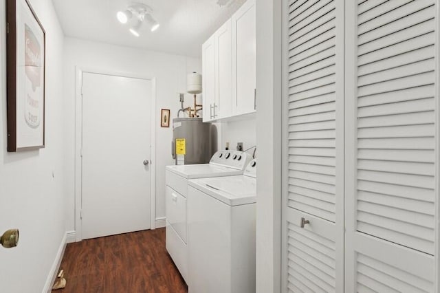 clothes washing area with dark wood-type flooring, cabinets, electric water heater, and washing machine and clothes dryer