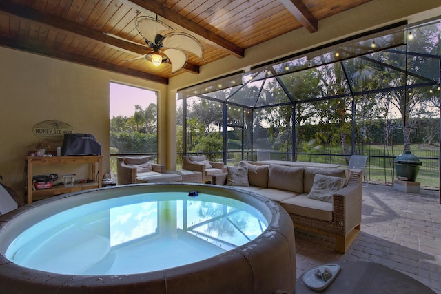 pool at dusk featuring a lanai, outdoor lounge area, a patio, and ceiling fan