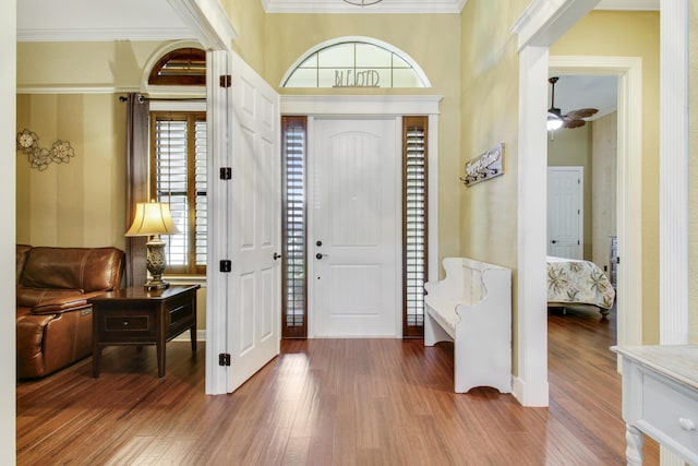 entryway with hardwood / wood-style floors, crown molding, and ceiling fan