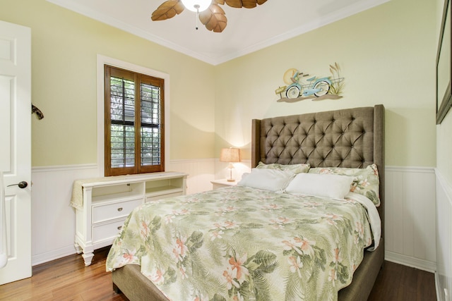 bedroom with hardwood / wood-style flooring, ceiling fan, and ornamental molding