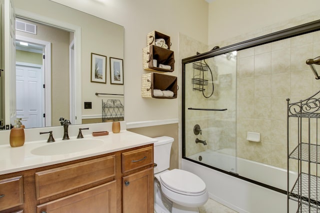 full bathroom with toilet, vanity, and bath / shower combo with glass door