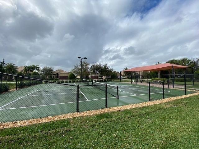 view of tennis court with a lawn