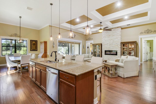 kitchen with dark wood-type flooring, a kitchen island with sink, dishwasher, and sink