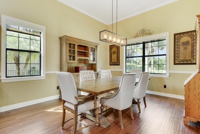 dining room featuring hardwood / wood-style flooring, crown molding, and an inviting chandelier