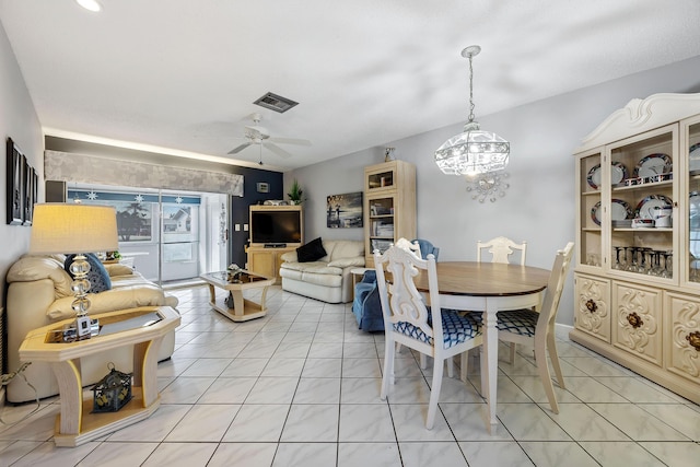 dining space with light tile patterned floors and ceiling fan with notable chandelier