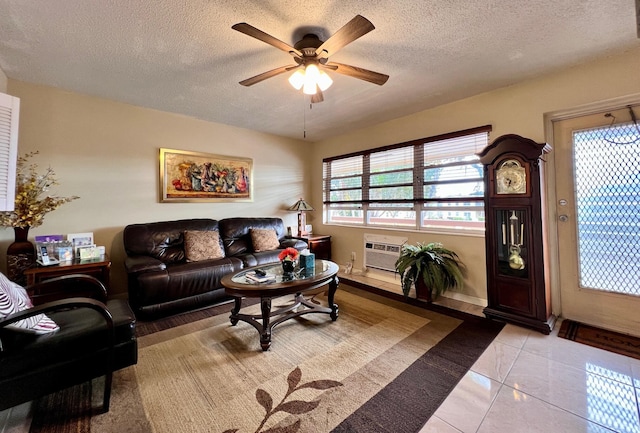 living room featuring ceiling fan, plenty of natural light, a wall mounted AC, and a textured ceiling