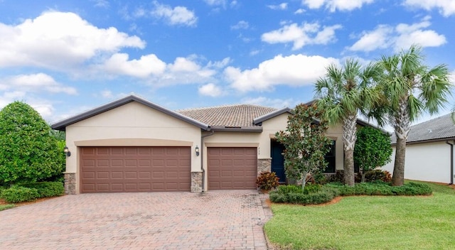 view of front of property with a garage, stone siding, stucco siding, decorative driveway, and a front yard