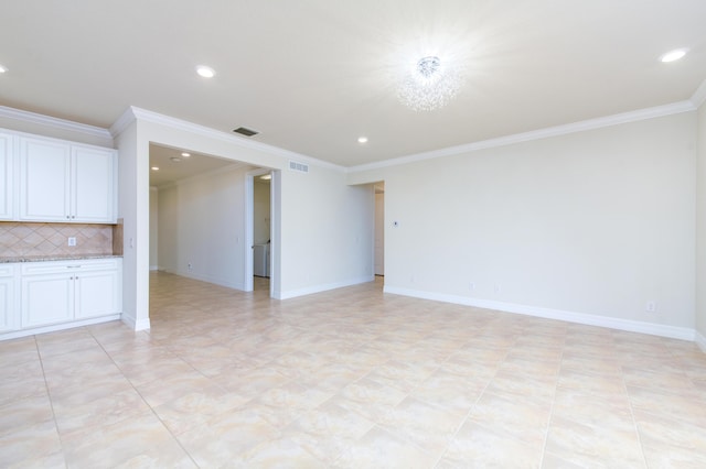 unfurnished living room featuring crown molding, visible vents, and baseboards