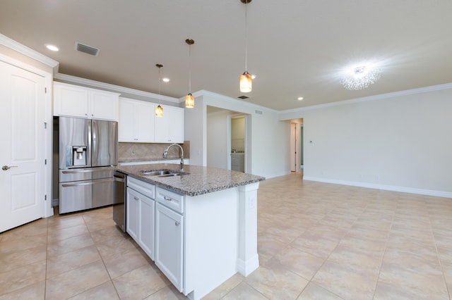 kitchen featuring visible vents, an island with sink, stainless steel appliances, stone counters, and a sink