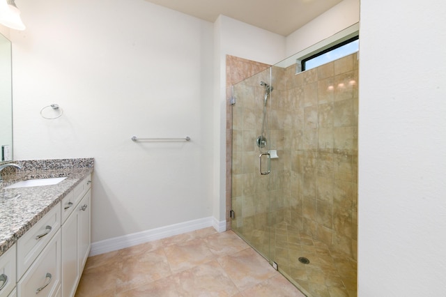 bathroom with a shower stall, vanity, and baseboards