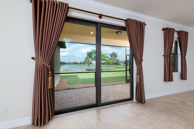 entryway featuring a water view, baseboards, ornamental molding, and tile patterned flooring