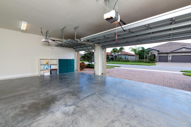 garage featuring a garage door opener and baseboards