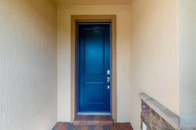 entrance to property with stucco siding