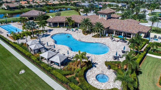 pool with a lawn, a patio area, fence, and a residential view