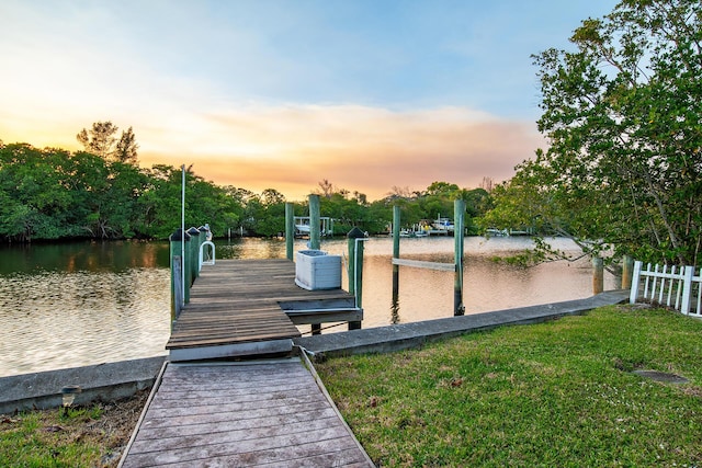 view of dock featuring a water view and a yard