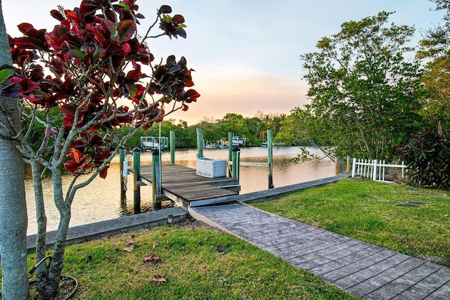 view of home's community with a lawn, a boat dock, and a water view