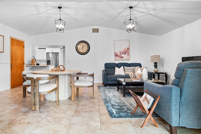 living room featuring a notable chandelier, vaulted ceiling, and light tile patterned flooring