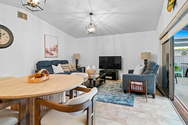 tiled living room featuring lofted ceiling and an inviting chandelier