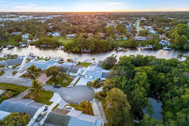 aerial view at dusk featuring a water view