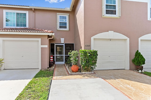 townhome / multi-family property featuring concrete driveway and stucco siding