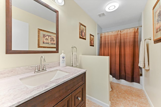 bathroom with visible vents, vanity, toilet, and baseboards