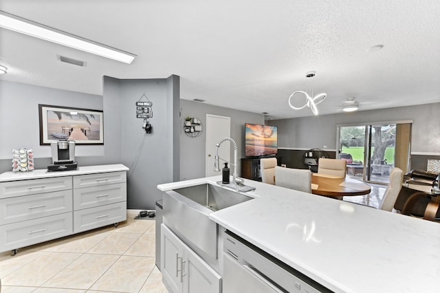 kitchen featuring light countertops, dishwasher, visible vents, and light tile patterned floors