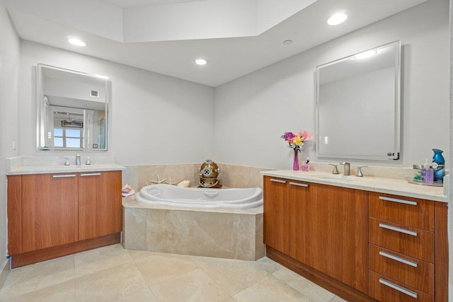 bathroom with tile patterned flooring, vanity, and tiled tub