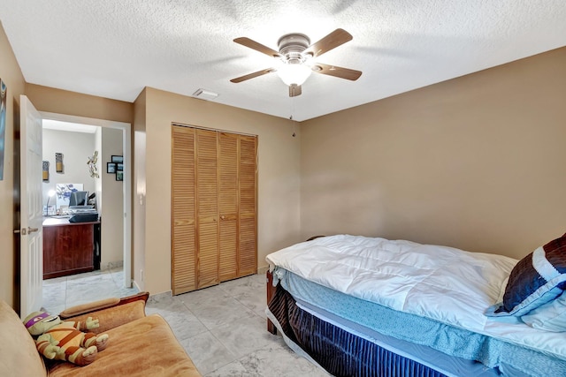 1075 E Lancewood Pl, Delray Beach, FL 33445 - bedroom featuring a closet, a ceiling fan, a textured ceiling, and light marble finish floors