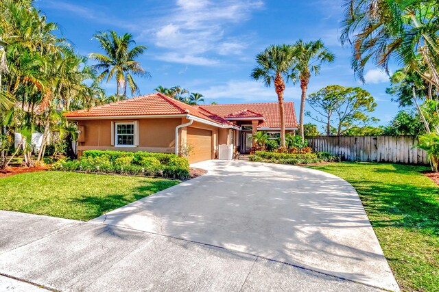 1075 E Lancewood Pl, Delray Beach, FL 33445 - view of front facade with a tiled roof, concrete driveway, stucco siding, and a garage