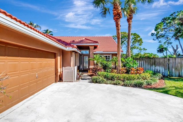 1075 E Lancewood Pl, Delray Beach, FL 33445 - mediterranean / spanish-style house with a tile roof, fence, stucco siding, and a garage