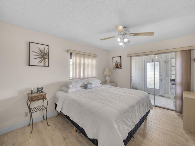 12 Valencia Unit A, Delray Beach, FL 33446 - bedroom featuring light wood-style floors, a textured ceiling, multiple windows, and access to exterior