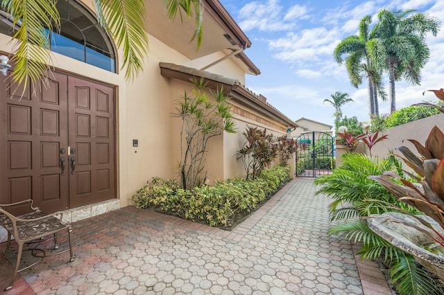 6525 Via Benita, Boca Raton, FL 33433 - property entrance featuring stucco siding, fence, and a gate