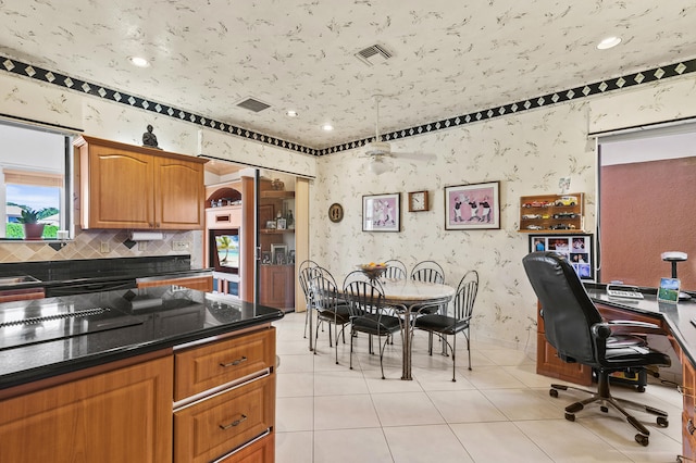 6525 Via Benita, Boca Raton, FL 33433 - kitchen featuring light tile patterned floors, visible vents, brown cabinets, and wallpapered walls