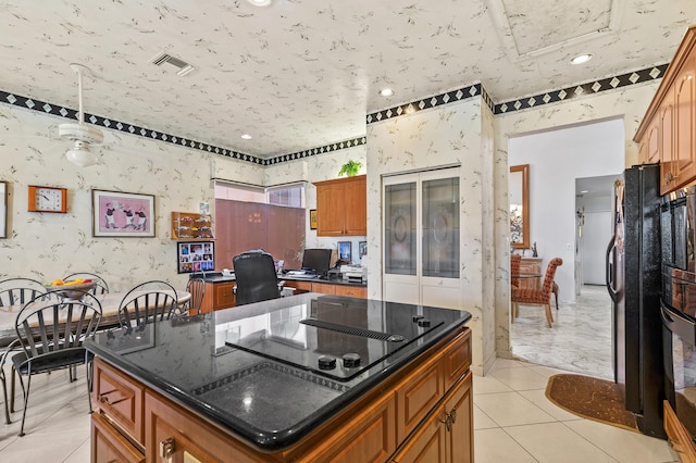 6525 Via Benita, Boca Raton, FL 33433 - kitchen featuring visible vents, a kitchen island, wallpapered walls, brown cabinetry, and black appliances