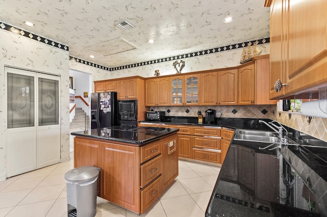 6525 Via Benita, Boca Raton, FL 33433 - kitchen with visible vents, light tile patterned floors, brown cabinetry, black appliances, and a sink