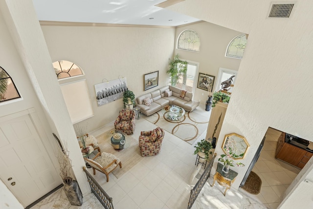 6525 Via Benita, Boca Raton, FL 33433 - tiled living area featuring visible vents, crown molding, and a high ceiling