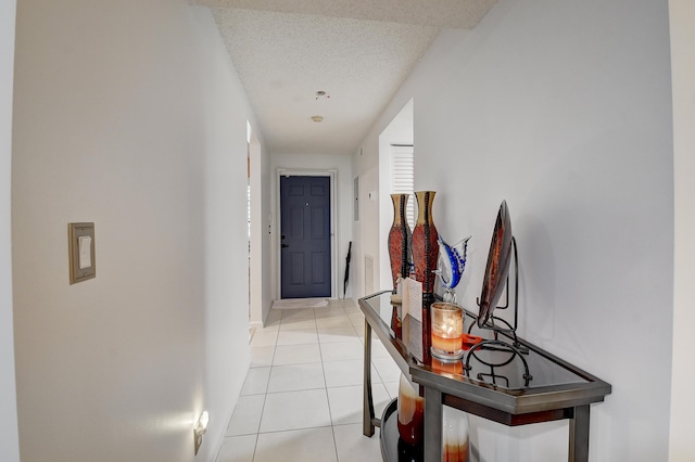 hall with light tile patterned flooring and a textured ceiling