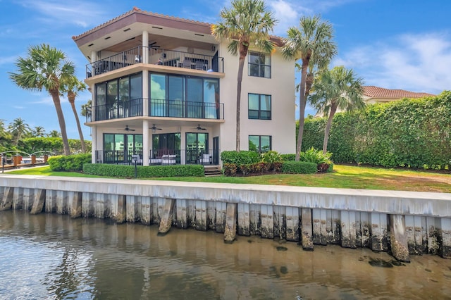 800 Andrews Ave Unit 9, Delray Beach, FL 33483 - back of property featuring a water view, stucco siding, ceiling fan, a balcony, and a yard