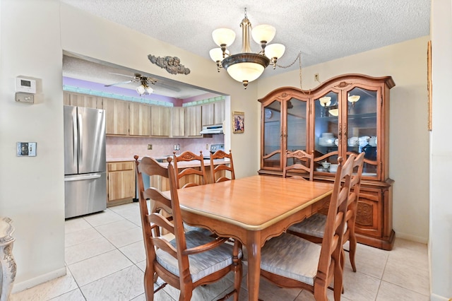 tiled dining room featuring ceiling fan with notable chandelier and a textured ceiling