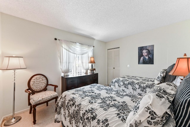 tiled bedroom with a closet and a textured ceiling