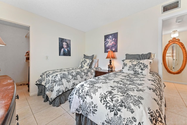 tiled bedroom featuring a textured ceiling