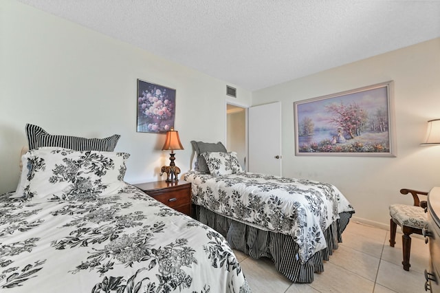 bedroom featuring light tile patterned flooring and a textured ceiling