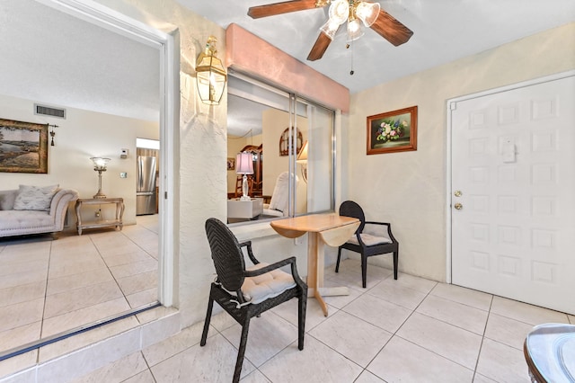 tiled foyer with ceiling fan